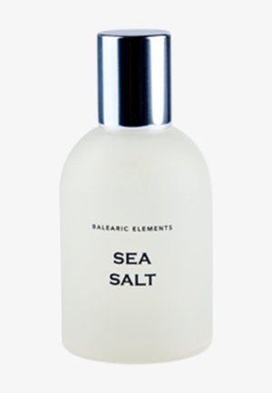 Maturowana szklana butelka perfum w kształcie okrągłym, z metalową srebrną zakrętką oraz wyraźnym czarnym napisem "SEA SALT" i "BALEARIC ELEMENTS."