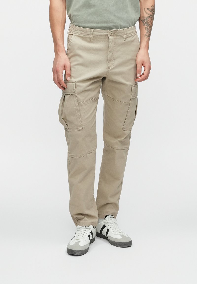 Pantalones cargo beige con múltiples bolsillos, hechos de tejido duradero. Presentan un diseño de pierna recta y costuras reforzadas para mayor resistencia.
