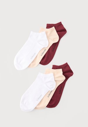 Setovi od tri gležnjače u bijeloj, bež i bordo boji, ravno posloženi na svijetloj podlozi.