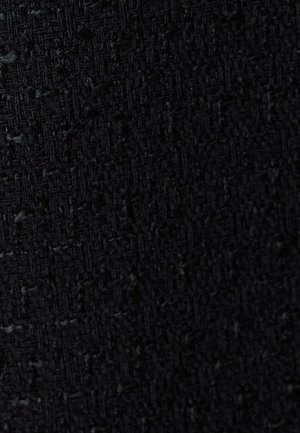 Texturiertes schwarzes Gewebe mit einem gewebten Muster und einem subtilen Rautendesign, das auf ein haltbares und strukturiertes Material hinweist.