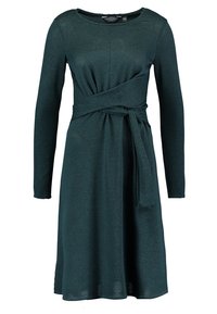 Tmavě zelené šaty s dlouhým rukávem a designem do požehnání, s páskem v pase, vyrobené z jemné látky a s hladkým povrchem.