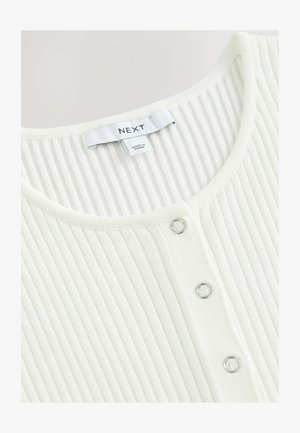 Biała bluzka prążkowana z głębokim dekoltem, z trzema srebrnymi zatrzaskami z przodu oraz metką z napisem "NEXT". Wykonana z miękkiego materiału.