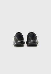 Schwarze Sportschuhe mit einem strukturierten Mesh-Obermaterial, einem runden Fersendesign und Gummisohlen mit einem gemusterten Grip. Keine sichtbaren Marken.
