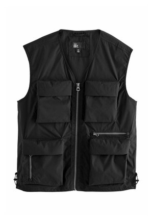 Veste utilitaire noire avec fermeture éclair à l’avant et quatre grandes poches à rabat, dont deux avec compartiments zippés supplémentaires, design sans manches, étiquette taille moyenne.