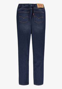 Mörkblå denimjeans med en bekväm elastisk midja, två bakfickor och en tanfärgad läderetikett på baksidan.