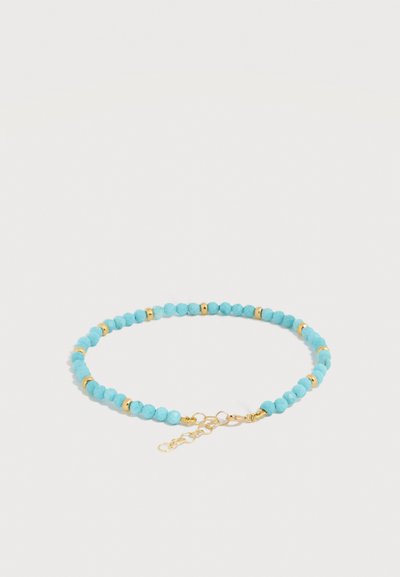 Λεπτό βραχιόλι με μικρές στρογγυλές τυρκουάζ χάντρες και χρυσά διαχωριστικά χάντρες, με χρυσή προσαρμοζόμενη αλυσίδα κλεισίματος.