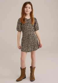 Haljina s uzorkom leoparda koja ima kratke napuhane rukave, strukirani gornji dio i lepršavu suknju. Nosila se s smeškim suedenim kaubojskim čizmama.