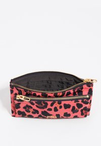 Rozā un melnā leopardu raksta soma, ar rāvējslēdzēju un zelta krāsas akcentu. Iekšējā daļa ir oderēta, ar kabatām kartēm.