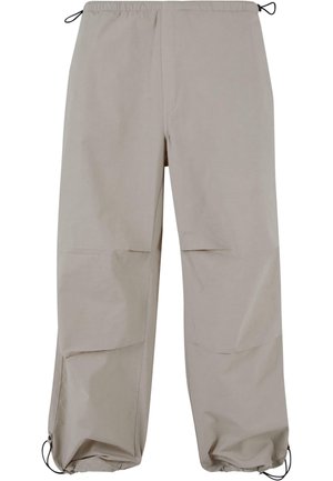 Lyse beige, vide bukser med elastisk linning og snoretræk. Har to sidelommer og elastiske manchetter ved anklerne.