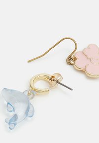Brincos em tom dourado com uma flor rosa e um charme de golfinho azul claro. O design inclui detalhes em esmalte e um fecho em gancho.