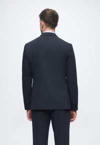 Marineblauer Sakk jacket mit glatter Textur, schmaler Passform, schmalen Revers und zwei Rückenschlitzen. Mit Knopfdetails an den Ärmeln.