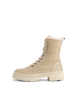 Beige Wildleder-Stiefeletten mit strukturiertem Finish, Fellfutter am oberen Rand, Metallösen und einer dicken, geriffelten Gummisohle.