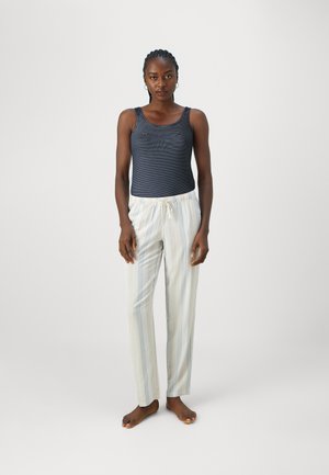 Top senza maniche blu navy con righe orizzontali abbinato a pantaloni del pigiama chiari a righe. I pantaloni presentano un elastico in vita e un cordoncino.