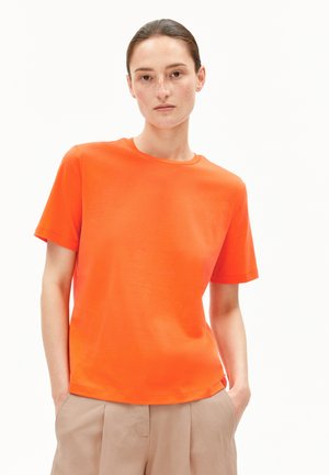 Korte mouwen t-shirt in helder oranje, gemaakt van glad katoen met een ronde hals en een relaxte pasvorm. Gecombineerd met beige, geplooide broeken.