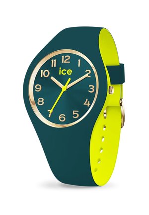 Green silicone watch featuring a gold-tone bezel, large yellow numerals, and two yellow hands on a dark green dial. Yellow strap accents included.
