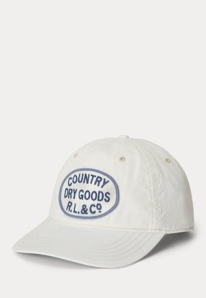 Casquette de baseball blanche en coton avec un patch ovale bleu sur le devant indiquant "COUNTRY DRY GOODS R.L. & Co.", visière légèrement incurvée.