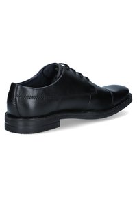 Zwarte leren jurk schoen met een gladde afwerking, ronde teen en gestikte details. Beschikt over een low-profile rubberen zool en vetersluiting.