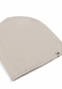 Beige knit beanie with a soft texture, rounded top, and a small tag at the hem. Simple design suitable for various outfits.
