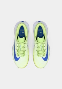 Ein Paar neongelbe und blaue Nike Vapor Pro Sneaker von oben auf weißem Hintergrund betrachtet.