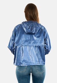 Blauwe, glanzende, lichte hooded jack met een losse pasvorm en een elastische tailleband. Glad textuur, geen zichtbare patronen of hardware details.