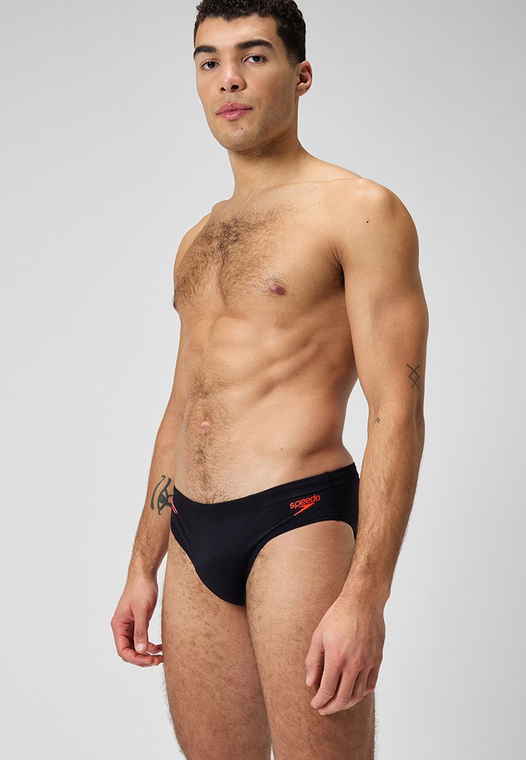 Caleçons de bain noirs avec logo "Speedo" rouge, design élégant, hauteur de taille standard, fabriqués en matériau lisse et extensible.