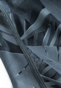 Schwarzer und grauer Stoff mit einem glatten Textur, der eine zentrale Naht und blattähnliche Designelemente aufweist. Geeignet für Sportbekleidung.