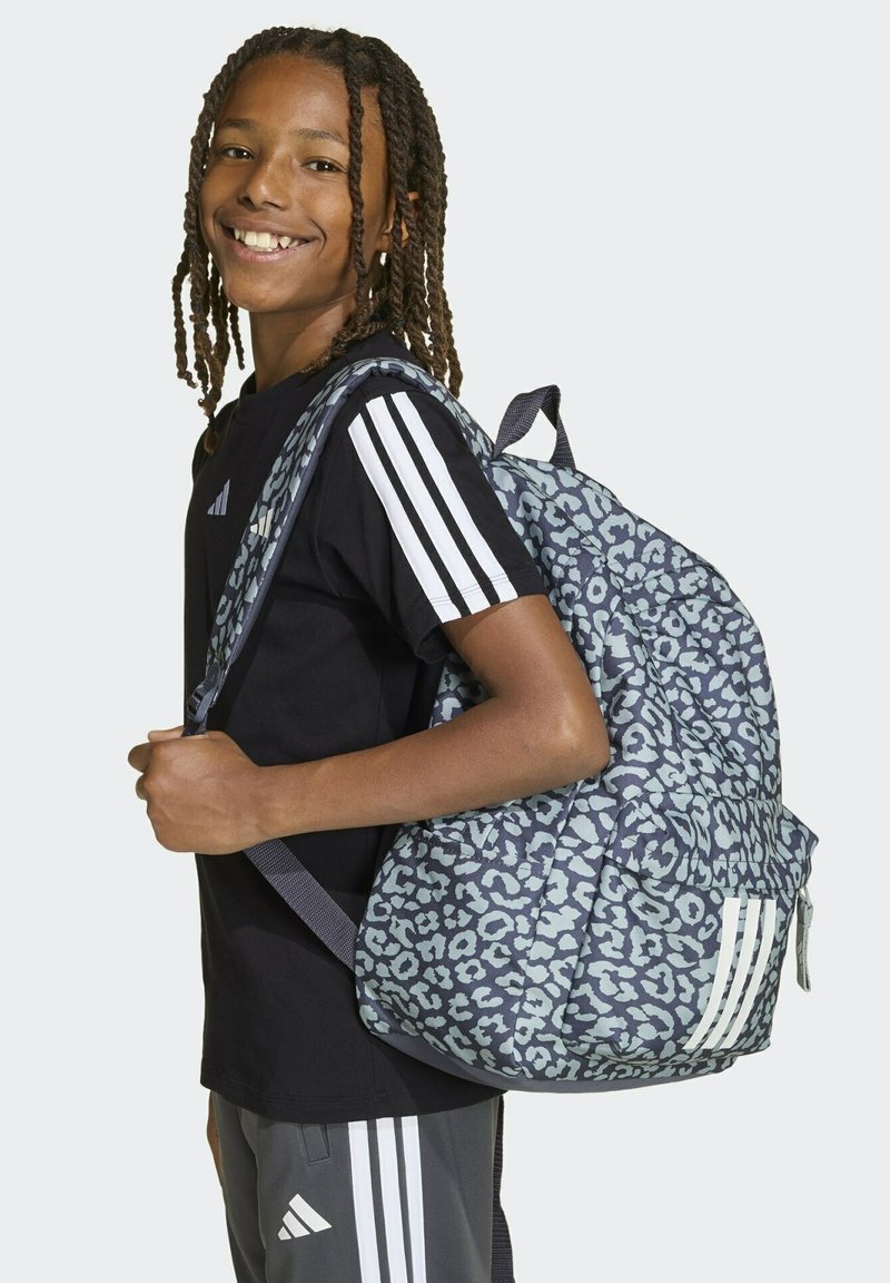 Mochila con estampado de leopardo azul y correas acolchadas, con un bolsillo con cremallera y tres franjas blancas en el frente. Ajustable para mayor comodidad.