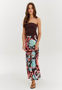 Hnedý bezramienkový top v kombinácii s dlhou maxi sukňou s mnohobarevným abstraktným vzorom ružových, modrých a zelených vírov.