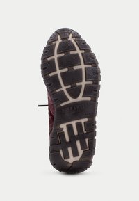 Semelle de chaussure de randonnée avec un design en caoutchouc noir texturé et un accent marron. Le motif de la semelle présente des rainures pour une adhérence et une stabilité accrues.