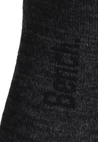 Black knitted socks featuring a textured pattern and visible branding in a darker shade. Soft, flexible material for comfort.