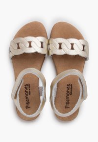 Light beige sandals with woven metallic strap, cork footbed, adjustable heel strap, and textured sole. Brand logo printed on the insole.