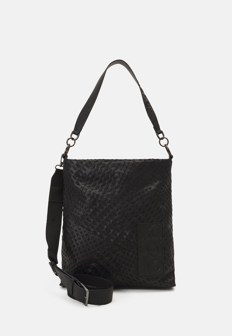 Sac à épaule noir texturé avec bandoulière réglable et patch logo embossé sur la face lisse, sur fond blanc uni.