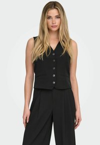 Zwart mouwloos vest met een V-hals, knoopsluiting aan de voorkant en twee steekzakken. Gemaakt van gladde stof, met een getailleerde pasvorm.