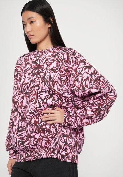 Sudadera de gran tamaño en rosa con patrones florales oscuros, con un escote y puños acanalados, y un corte relajado, elaborada en una tela suave.
