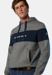 Felpa con cappuccio grigia e blu navy, caratterizzata da una tasca a marsupio frontale, un design a blocchi di colore orizzontali e testo del logo bianco. Tessuto morbido.