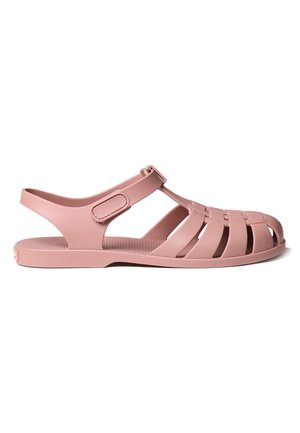 Pink plastic sandals with a strap and cut-out designs for breathability. Flat sole with a textured footbed, suitable for casual wear.