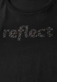 Černé tričko s vystouplým tečkovaným vzorem s nápisem "reflect" ve stříbrných ozdobách. Kulatý výstřih, měkká textura a ležérní střih.
