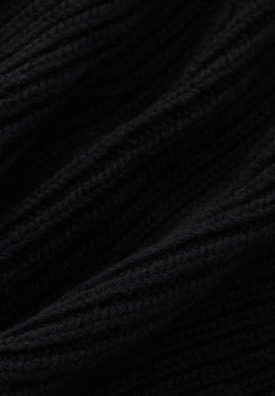 Aproximação de um tecido preto de malha com uma textura canelada e textura macia e espessa, mostrando pregas e sombras.
