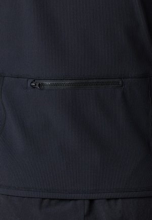 Marineblaues, mit Reißverschluss versehenes Jacket mit strukturiertem Material, das auf der Rückseite eine horizontale Reißverschlusstasche und flache Nähte am Saum und den Seiten aufweist.
