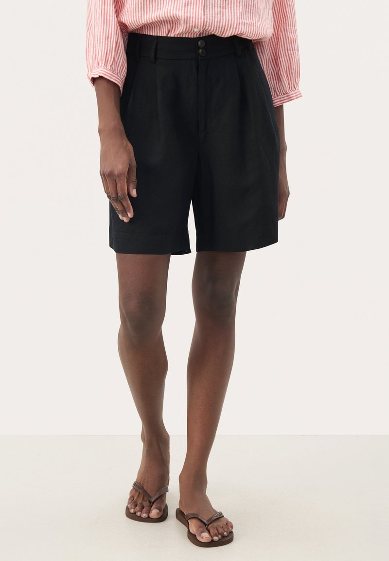 Zwarte linnen shorts met een tailor-fit, met een hoge taille, twee voorplooien en een sluiting met twee knopen. Eenvoudig, strak ontwerp met cleane lijnen.