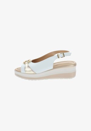 Sandalia de cuña blanca con detalle dorado, puntera abierta, correa ajustable en el tobillo y suela beige acolchada.