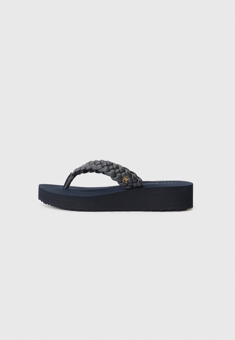 Mornarske japanke s pletenom trakom i teksturiranom potplatom. Imaju blagi wedge i mali zlatni logo na traci. Izrađene od gumene tvari.