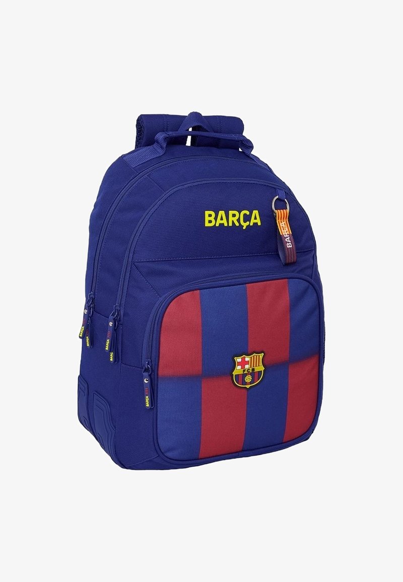Niebieski plecak w czerwono-niebieski paski, z napisem "BARÇA" w żółtym kolorze. Posiada naszywkę z logo, wiele zamków błyskawicznych oraz wyściełane szelki.