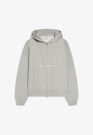 Jasnoszara bluza z kapturem zapinana na zamek, z przednią kieszenią, ściągaczami na rękawach i kapturem, na przodzie niewielki biały napis "WORLDWIDE STUDIO CONNECTION".