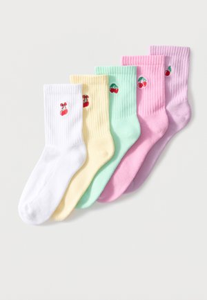 Cinq chaussettes côtelées de couleur pastel avec de petits motifs de cerises brodés, disposées côte à côte sur un fond blanc.