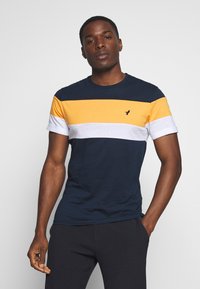 Short-sleeve T-shirt in navy, yellow, white, and gray stripes. Features a crew neck and a small logo on the chest. Made of cotton blend.