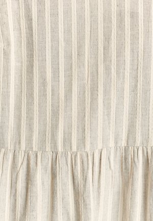 Světlá látka s vertikálními pruhy v béžové a šedé barvě. Má texturovaný povrch a na spodním okraji je nařasený, volánkový lem.