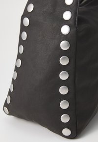 Black leather handbag featuring silver metal studs along the side, with a textured surface and a structured shape.