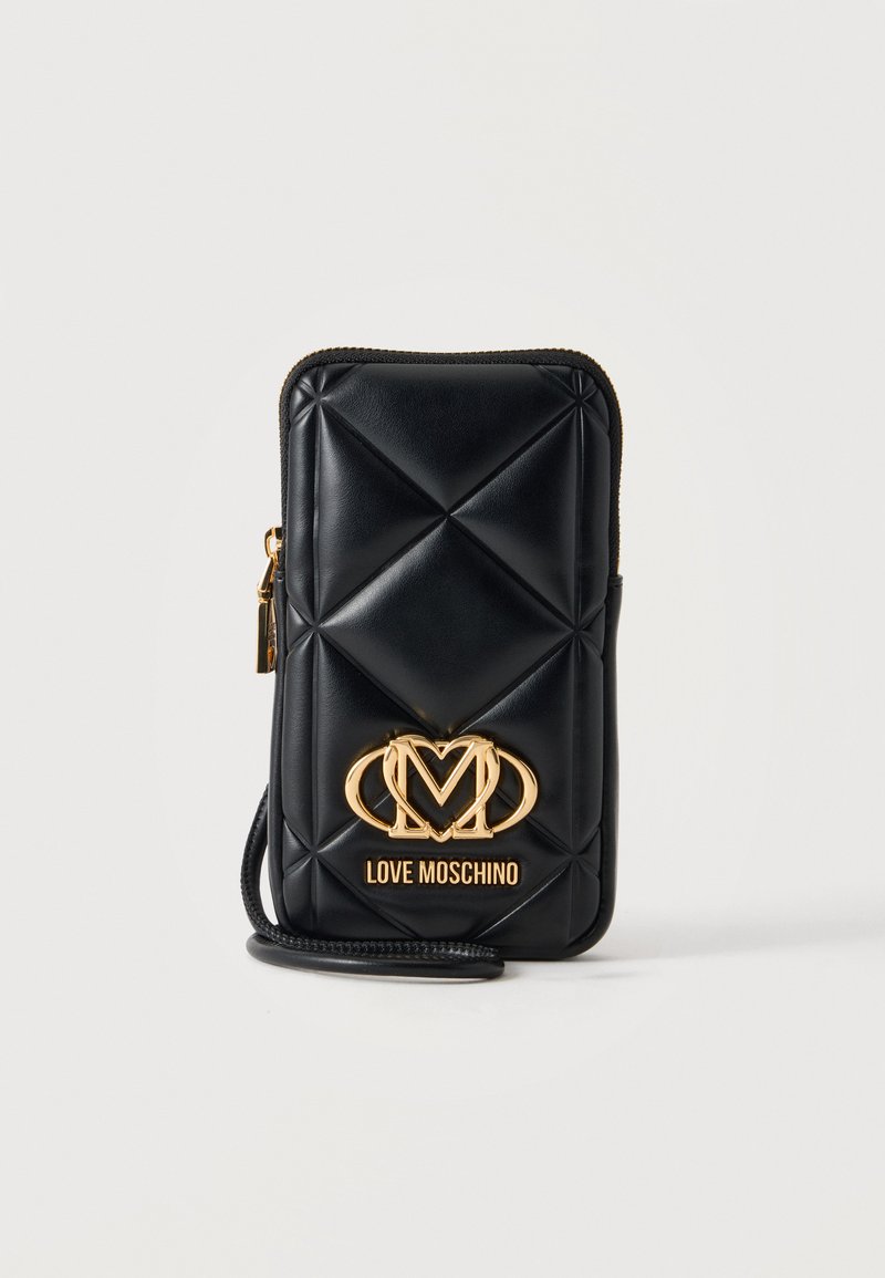 Μαύρο καπιτονέ δερμάτινο τσαντάκι Love Moschino με χρυσή πλακέτα λογότυπου και λουράκι για τον καρπό σε απλό φωτεινό φόντο.