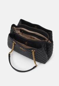 Czarna pikowana torebka na łańcuszku ze złotym łańcuszkiem i skórzanymi uchwytami, z przestronnym wnętrzem i wieloma przegródkami do organizacji.